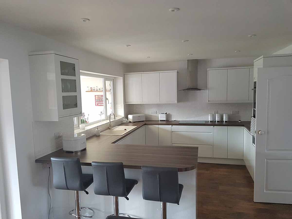 White gloss handleless kitchen with a breakfast bar
