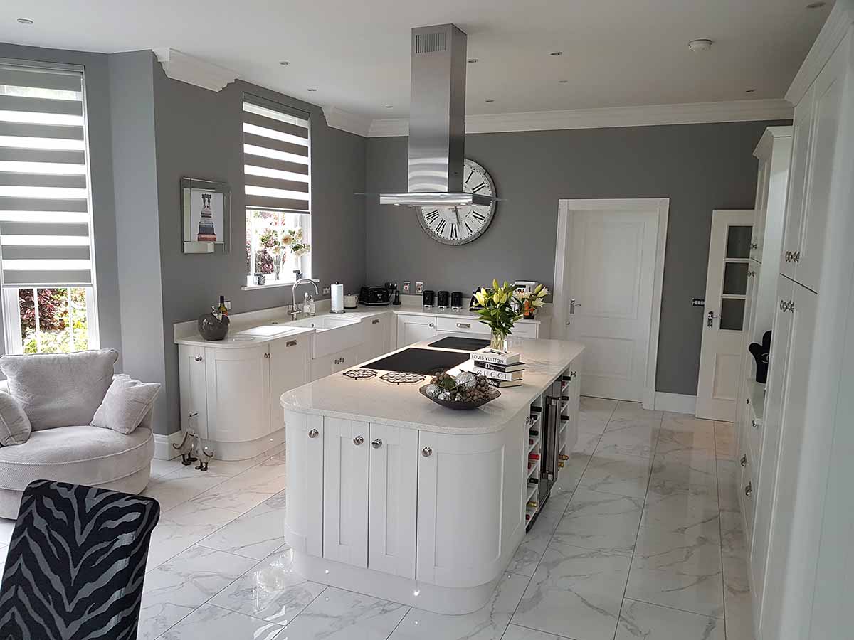 Painted white Shaker kitchen with a curved-end island, fitted by Arden Kitchens